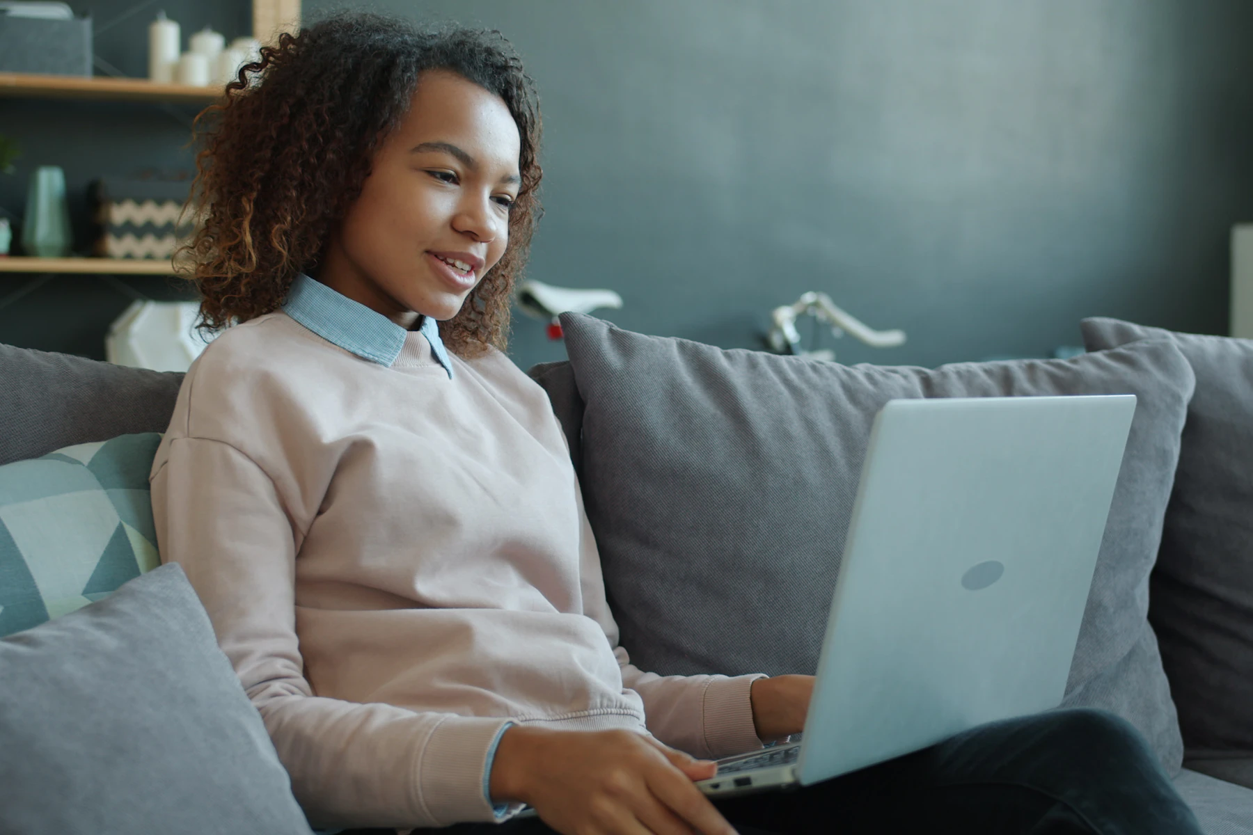 Paciente adulto em videochamada médica em casa, sentado à mesa com notebook, ambiente doméstico iluminado por luz natural